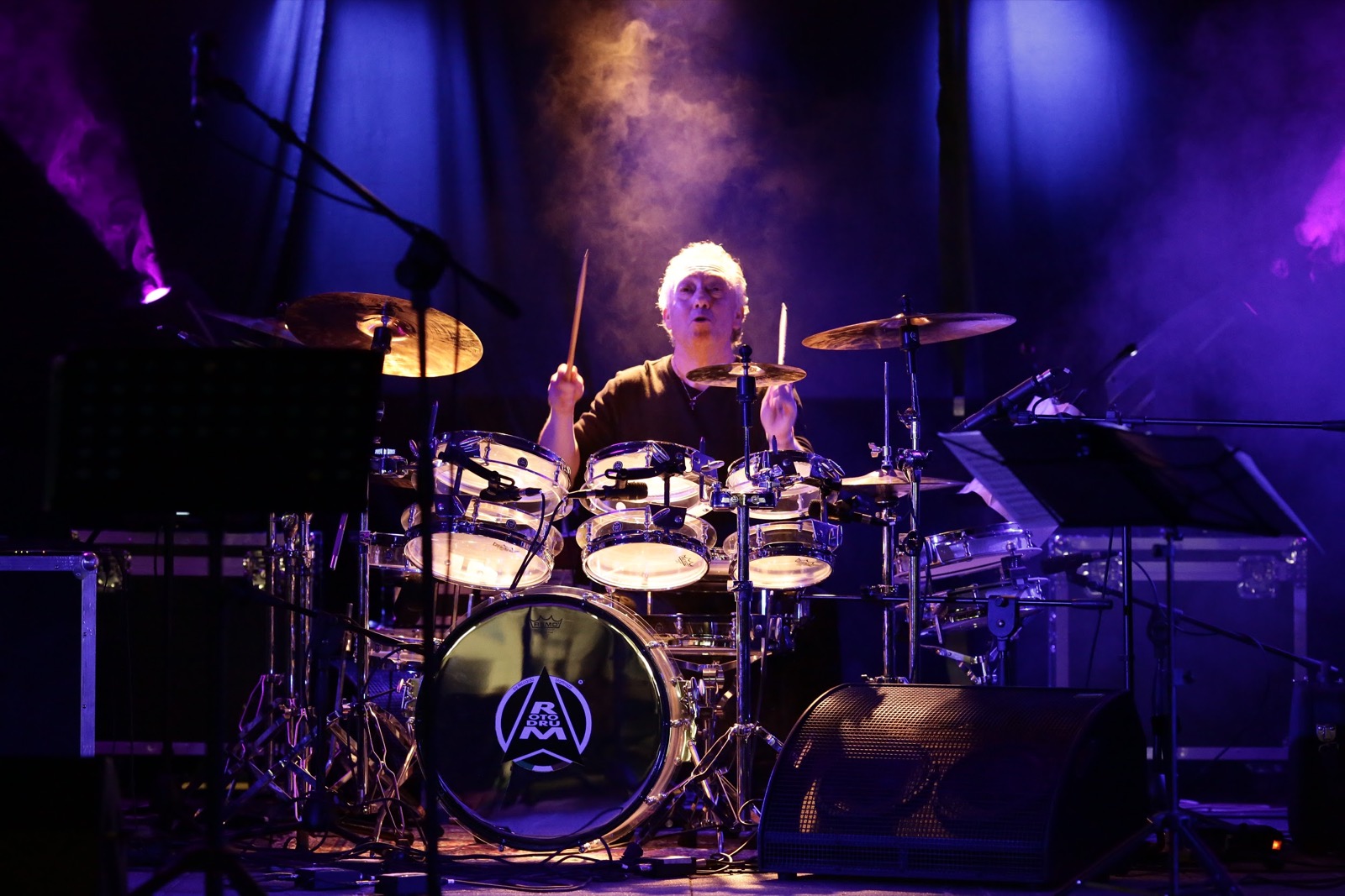 Mimmo Camporeale alla batteria, primo piano viola e blu con fumo scenico — Gabor Lesko Trio, Parco della Trucca Bergamo, SUONO E LUCE